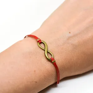 Red cord bracelet with a bronze endless infinity charm, yoga jewelry