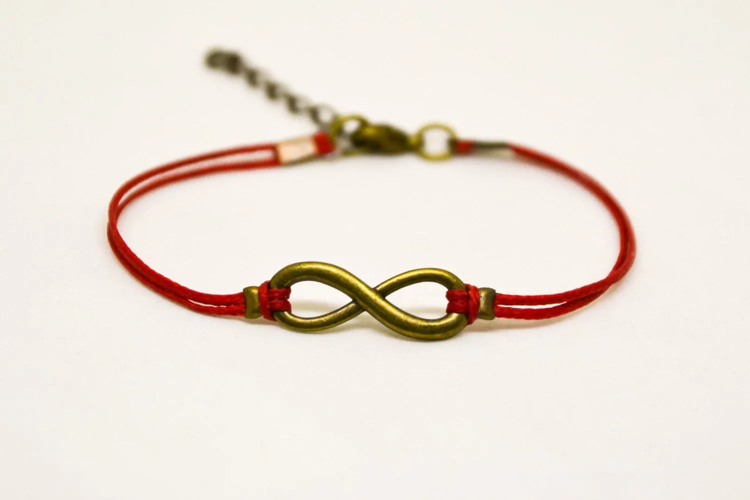 Red cord bracelet with a bronze endless infinity charm, yoga jewelry