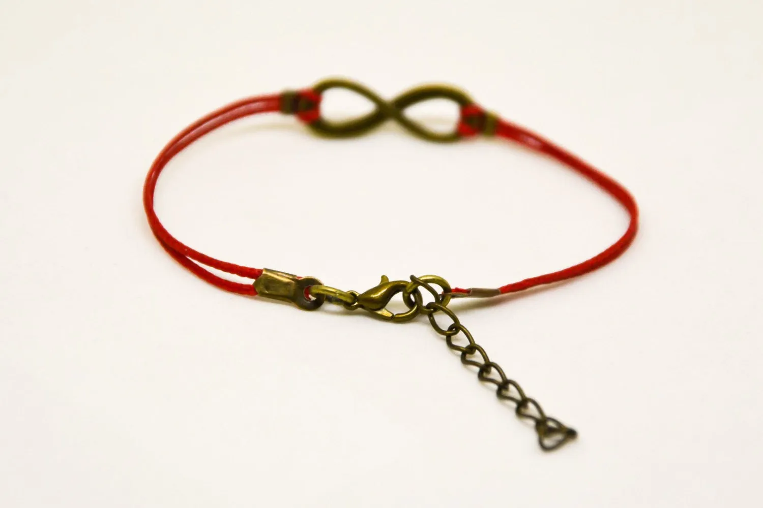 Red cord bracelet with a bronze endless infinity charm, yoga jewelry