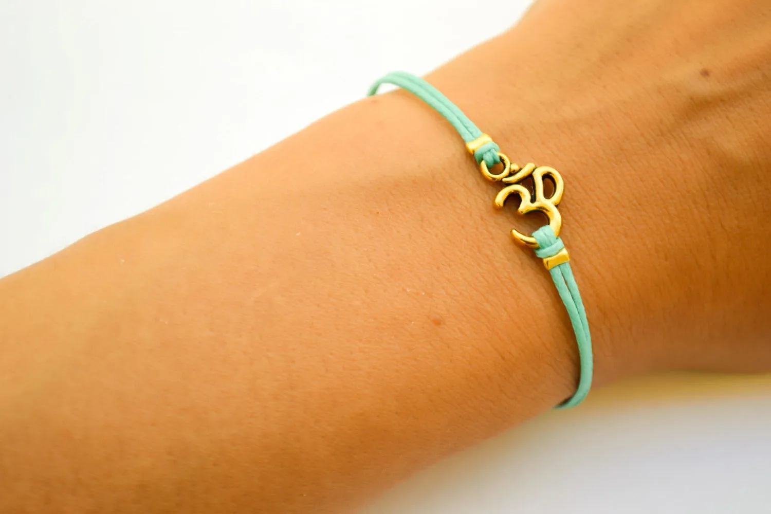 Turquoise cord bracelet with a gold tone Om charm, yoga jewelry