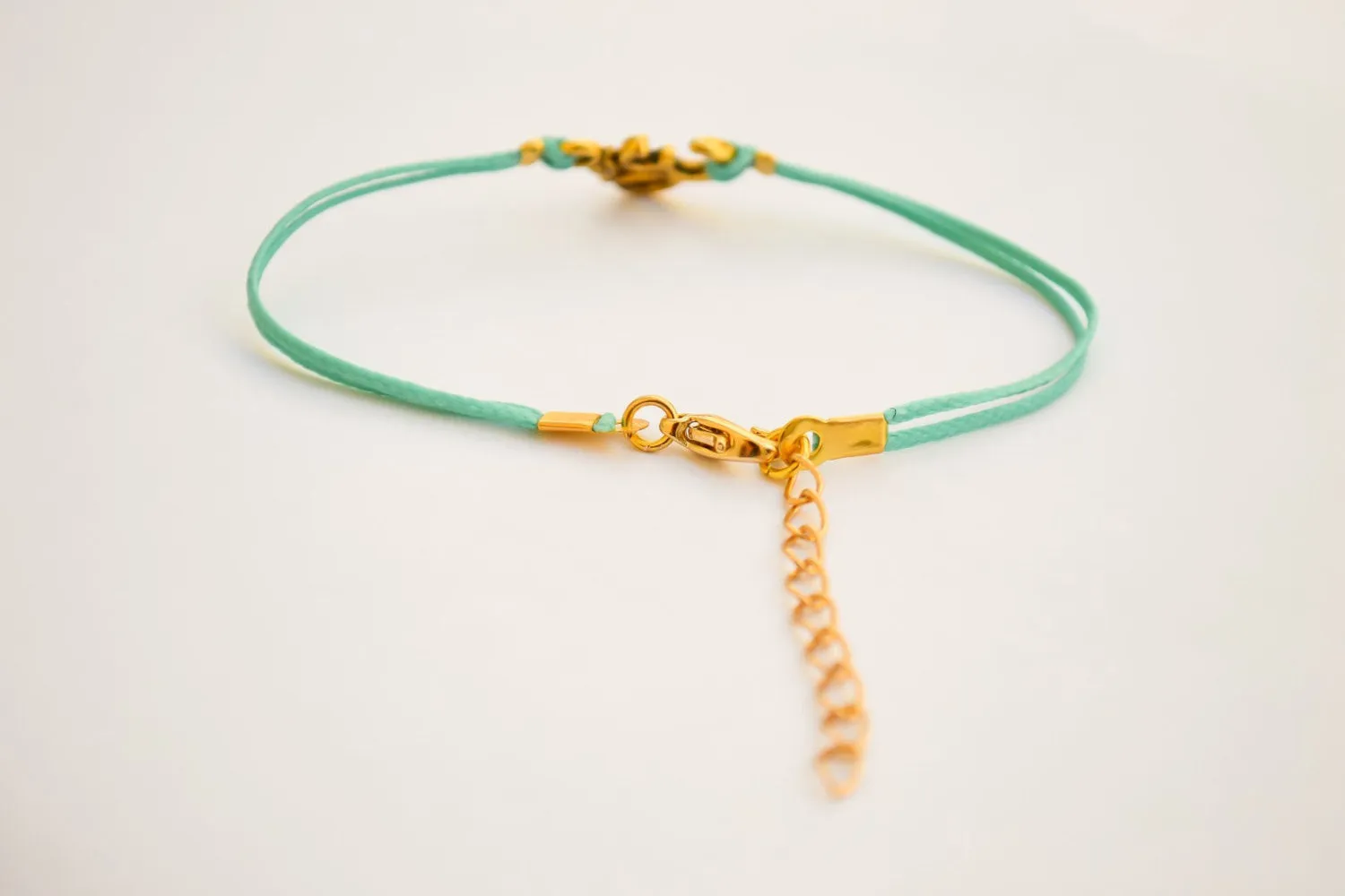 Turquoise cord bracelet with a gold tone Om charm, yoga jewelry