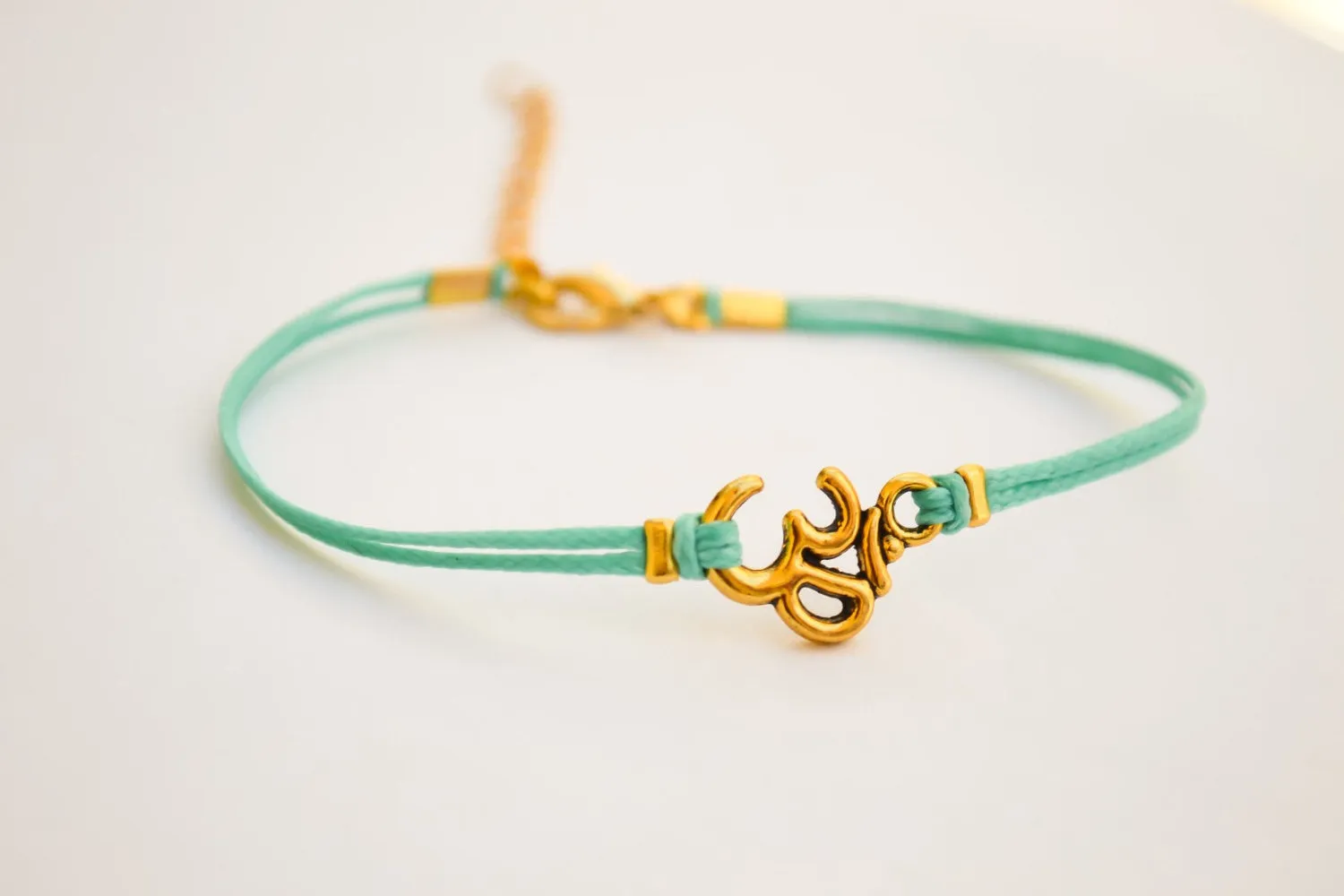 Turquoise cord bracelet with a gold tone Om charm, yoga jewelry