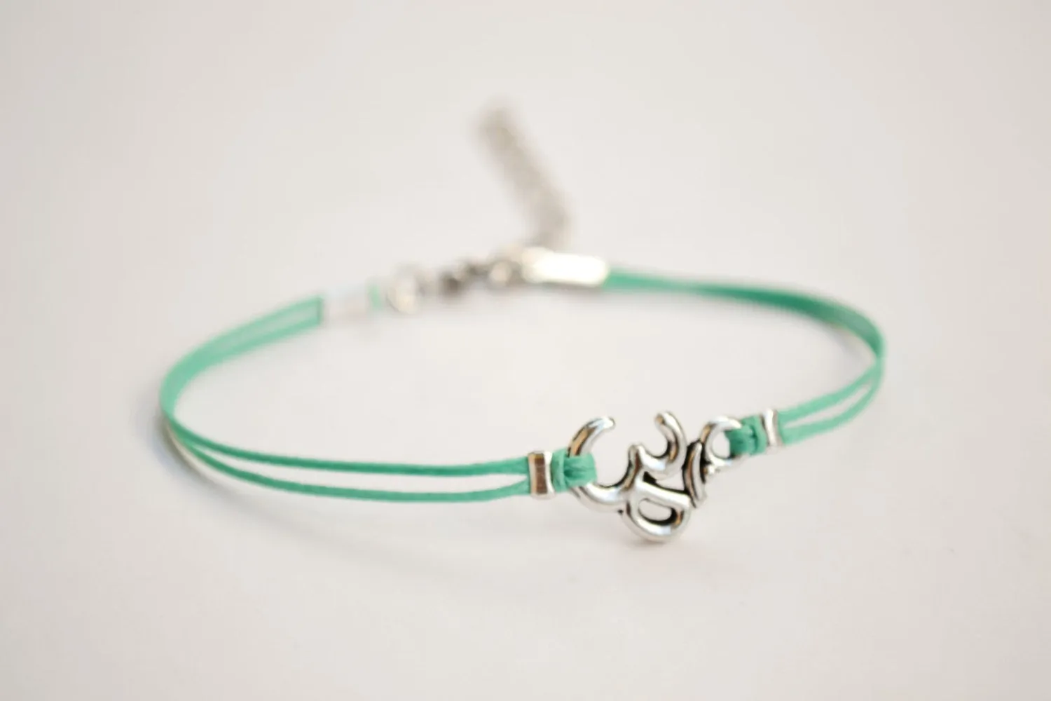 Turquoise cord bracelet with a silver Om charm, yoga jewelry